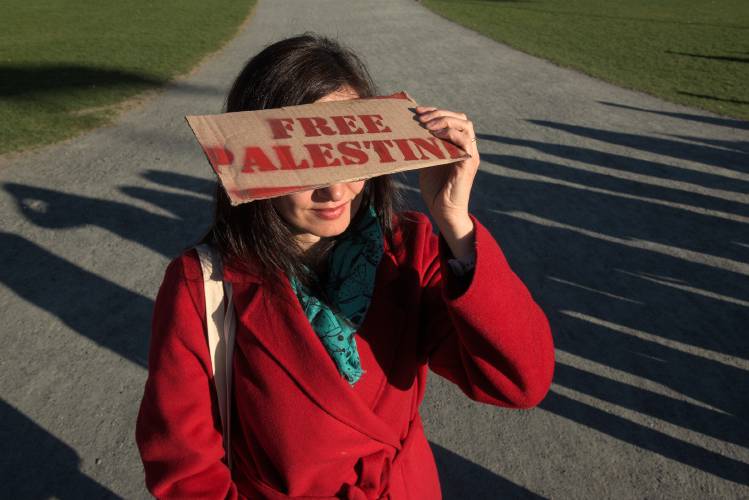 Esen Kara, a visiting scholar of literature at Dartmouth College from Turkey, shields her eyes from the sun during a protest of the war in Gaza on the green in Hanover, N.H., on Thursday, April 25, 2024. (Valley News - James M. Patterson) Copyright Valley News. May not be reprinted or used online without permission. Send requests to permission@vnews.com.