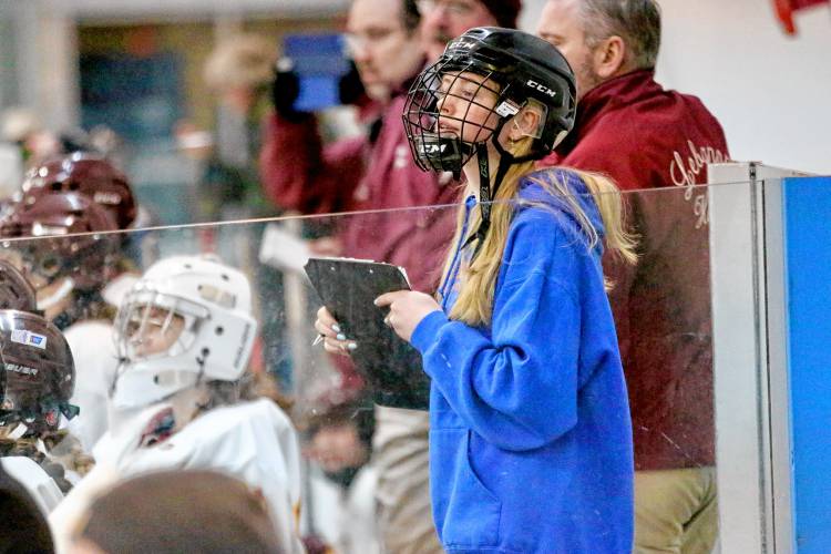 Lebanon High freshman Julia McGee cheers on her Lebanon-Stevens-Kearsarge ice hockey team during its NHIAA game against Oyster River-Portsmouth on Feb. 10, 2024, at Campion Rink in West Lebanon, N.H. McGee, out for the season because of a knee injury, keeps statistics on the Raiders bench during games. Oyster River-Portsmouth won, 3-0. (Valley News - Tris Wykes) Copyright Valley News. May not be reprinted or used online without permission. 